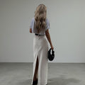 ZOFIA ATELIER white high-waist A-line maxi skirt with a back slit, made of spandex.