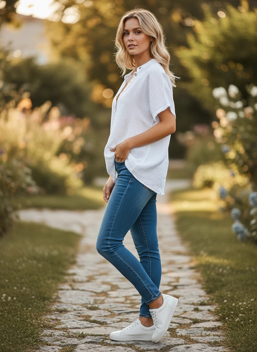 ZOFIA ATELIER white ramie V-neck short sleeve casual blouse on a woman wearing jeans outdoors.