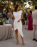 ZOFIA ATELIER white sleeveless asymmetric polyester dress with draped skirt and padded shoulders.