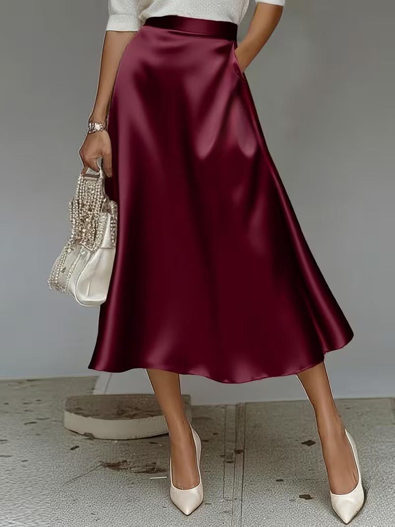 ZOFIA ATELIER wine red satin mid-length skirt with a slight stretch and pockets, paired with white heels.