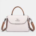 ZOFIA ATELIER ZYTA crossbody shoulder bag in light pink pebbled leather with brown trim and strap. Features a silver kangaroo logo.