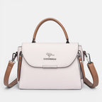 ZOFIA ATELIER ZYTA crossbody shoulder bag in light pink pebbled leather with brown trim and strap. Features a silver kangaroo logo.