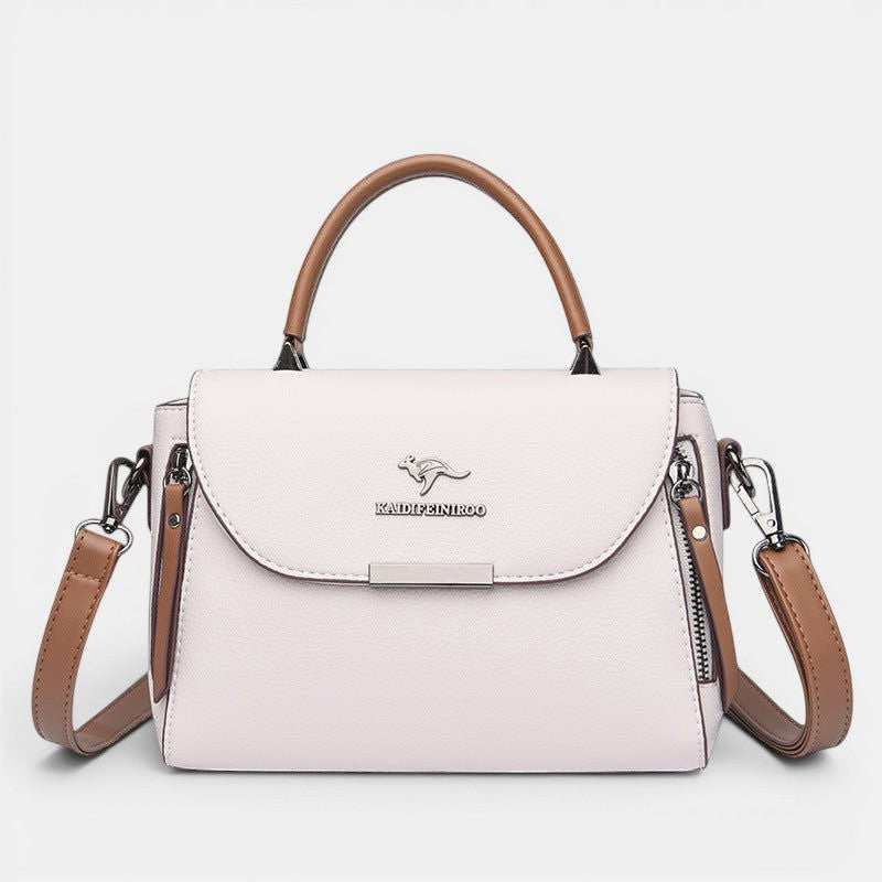ZOFIA ATELIER ZYTA crossbody shoulder bag in light pink pebbled leather with brown trim and strap. Features a silver kangaroo logo.